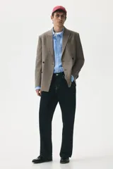 Blazer cruzado de tejido suave color beige/topo, con solapas de pico, ojal decorativo y cierre de doble botonadura. Posee bolsillo superior insertado, dos bolsillos delanteros ribeteados con solapa y botones decorativos en los puños.