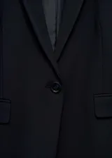 Blazer negro de corte recto y diseño clásico, con cuello de solapa con muesca, cierre frontal de un botón y dos bolsillos laterales con solapa.