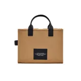 Bolso tipo tote bag Marc Jacobs modelo The Cargo Canvas Medium Tote Bag, de lona color tostado con detalles en negro. Cuenta con múltiples bolsillos frontales, asas superiores de cuero y correa de hombro ajustable y extraíble. Presenta la inscripción "THE TOTE BAG" y el logo de la marca bordados en el frente.