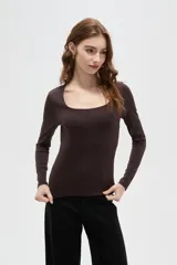 Top de manga larga color blanco, con cuello redondo amplio y ajuste al cuerpo.