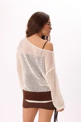 Set compuesto por un vestido corto liso de tirantes finos, un sweater de tejido de punto tipo red con mangas largas y un cinturón con flecos y detalle metálico.