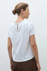 Remera de manga corta con frente confeccionado en tela broderie blanca con diseño calado y espalda de algodón liso.