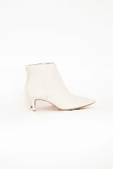 Bota corta de cuero color blanco off white, con taco fino de 6 cm y diseño en punta.