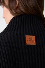 Capita de punto acanalado color negro, con cuello alto y diseño sin mangas.