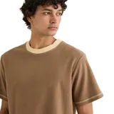 Remera de manga corta en tejido tipo toalla, color marrón con cuello redondo y costuras a contratono en color beige en el cuello, mangas y ruedo.