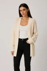 Cardigan de punto abierto, color natural, con diseño holgado, mangas largas y cuello en V. Presenta un cordón ajustable en la cintura.