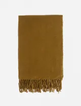 Bufanda tejida de textura suave, color mostaza, con diseño liso y terminación de flecos en los extremos.