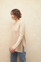 Polera negra de jacquard con cuello alto y aberturas en los laterales y en las mangas.