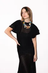 Vestido largo negro de encaje transparente con diseño geométrico, mangas cortas con volados y cuello alto.