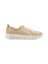 Sneaker Furla de cuero color beige, con suela anatómica elevada blanca, cordones blancos y detalle de elástico fruncido en el tobillo.