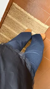 Pantalón de denim oscuro con corte recto y tiro medio. Presenta bolsillos traseros, cierre lateral invisible y tiras ajustables en la cintura.