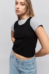 Musculosa de calce ajustado confeccionada en tejido acanalado, con escote redondo y detalle de puntilla en el escote y las sisas.