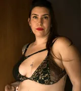 Corpiño de encaje negro con detalles dorados, de corte triangular y breteles finos.