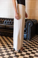 Pantalón blanco de sarga sastrera, de pierna recta y ancha, con bolsillos laterales en la parte delantera y pinza de ajuste en la espalda.