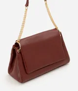 Cartera tipo shoulder bag de tamaño grande, confeccionada en poliuretano con textura de efecto croco. Presenta una solapa frontal con cierre magnético, herrajes en tono dorado claro y una correa de cadena metálica. Incluye un bolsillo interno con cremallera.