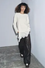 Camiseta color crudo de cuello redondo y manga larga, con detalle de aplicación de tejido lencero asimétrico a tono en el ruedo.