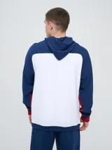 Campera deportiva Umbro del Club Nacional de Football, modelo con capucha, cierre frontal, bolsillos laterales y mangas raglán. Diseño en color blanco con mangas y detalles en azul marino y rojo.