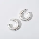 Aros plateados con forma de medialuna gruesa.