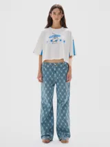 Pantalón de jean de tiro medio, corte flare, confeccionado en algodón y con estampado a cuadros en tonos azules.