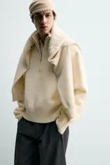 Jersey de punto color blanco con efecto pelo, cuello subido y cierre frontal de cremallera, de corte regular fit y manga larga con acabados en rib.