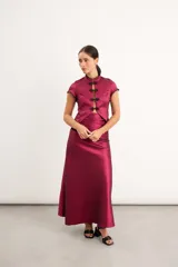 Falda larga de tafeta color bordó, con caderín drapeado y detalles en puntilla negra.