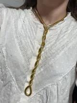 Collar dorado con diseño trenzado y cierre ajustable.