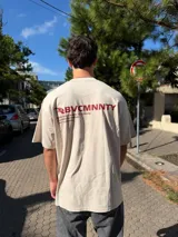 Remera de corte oversize color beige, con estampado gráfico en la espalda en color bordó que incluye el logo y texto descriptivo.