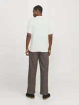 Polo de manga corta confeccionado en tejido de punto estructurado con textura sutil. Presenta cuello clásico, cierre frontal con tres botones y terminaciones en rib en mangas y ruedo.