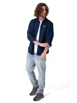 Camisa de manga larga de popelina color azul marino, de corte clásico con cuello camisero, cierre frontal con botones y bolsillo en el pecho con etiqueta de la marca Caterpillar. Incluye sistema para convertir las mangas en cortas.