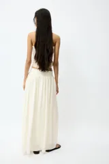 Pollera maxi de corte holgado en mezcla de viscosa, color beige. Cuenta con cintura en punto pesado con detalle fruncido en V que otorga una caída suave y fluida.
