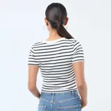 Remera de manga corta con cuello redondo, confeccionada en tejido de punto con estampado de rayas horizontales finas en color negro sobre fondo blanco.
