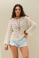Sweater de tejido abierto y calado color crudo, de manga larga y diseño holgado.