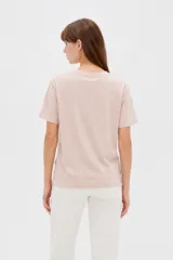 Remera de algodón blanca, de manga corta y cuello redondo, con estampado frontal de texto en color negro.