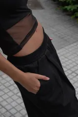 Bermuda negra de gabardina con pretina elástica, tiro bajo y bolsillos laterales. Presenta un pliegue delantero de gran tamaño.