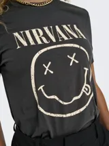 Remera de algodón con cuello redondo y mangas cortas. Presenta un estampado frontal con el logo y el icónico diseño de la banda Nirvana en tonos desgastados.