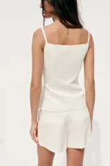 Shorts negros de tiro medio con cierre frontal de cremallera y gancho metálico. Presenta bolsillos delanteros ocultos en las costuras.