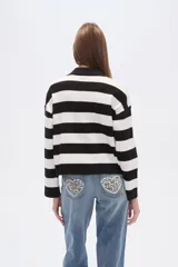 Sweater de tejido de punto con diseño de rayas horizontales en color beige y blanco, cuello polo con escote en V y mangas largas de corte holgado.