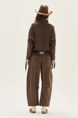 Polera de tejido de punto con diseño de ochos y detalles de tientos en contratono en las mangas. Presenta cuello alto y corte cropped.