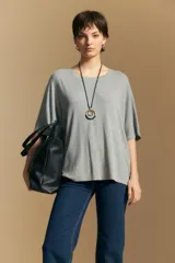 Remera de calce relajado con cuello redondo y mangas cortas, confeccionada en tejido de viscosa con elastano que brinda una caída fluida y suave.