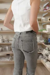 Jean oxford de tiro alto en color azul, con cortes horizontales y diagonales en las rodillas y detalles desflecados en el ruedo.