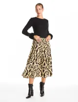 Falda midi de corte acampanado con diseño de estampado tribal en tonos negro y amarillo. Presenta una pretina ancha elastizada para mayor comodidad.