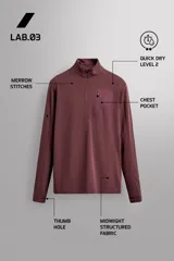 Sudadera técnica color vino tinto, de manga larga, con cuello subido y cierre frontal de cremallera. Presenta un bolsillo frontal con cierre de cremallera oculta en costura y detalle de logo estampado. El tejido tiene estructura waffle en el interior.