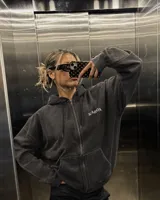 Hoodie de felpa suave color negro con efecto acid wash y corte oversize, con capucha y estampa gráfica en la espalda con diseño de palmeras y texto.