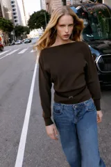 Jersey de punto color mostaza con cuello barco, manga larga con sisa ancha y detalle de cinturón fino integrado en la cintura.