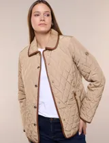 Campera matelaseada Michael Kors, de color beige con ribetes de ecocuero marrón. Cuenta con cuello con solapa, cierre frontal con broches metálicos, bolsillos laterales con cierre y mangas largas.