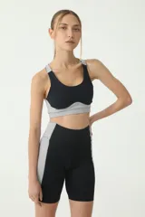 Top deportivo negro y gris con costuras blancas y logo BASSET 00,S estampado en la espalda.