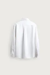 Camisa regular fit de hombre, confeccionada en denim fluido blanco con mezcla de lyocell, algodón y lino. Presenta cuello camisero, manga larga con puños abotonados, cierre frontal de botones y un bolsillo aplicado en el pecho.
