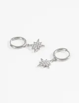 Aros tipo argolla de acero quirúrgico con dije colgante en forma de estrella de ocho puntas decorado con strass.