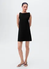 Vestido corto negro sin mangas, confeccionado en punto fino, con cuello barco y tirantes asimétricos.