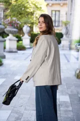 Blazer gris de poliéster y lana, de corte recto y textura sutil.